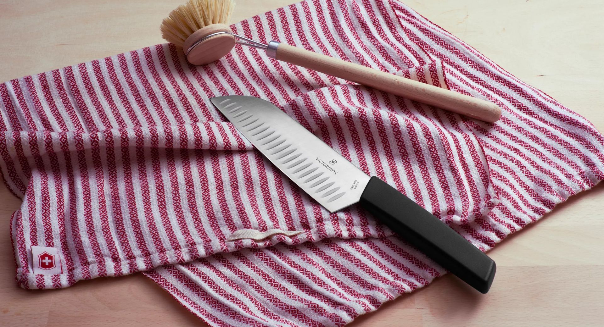 La mano del cuoco con un coltello affetta il pane su un tagliere da cucina