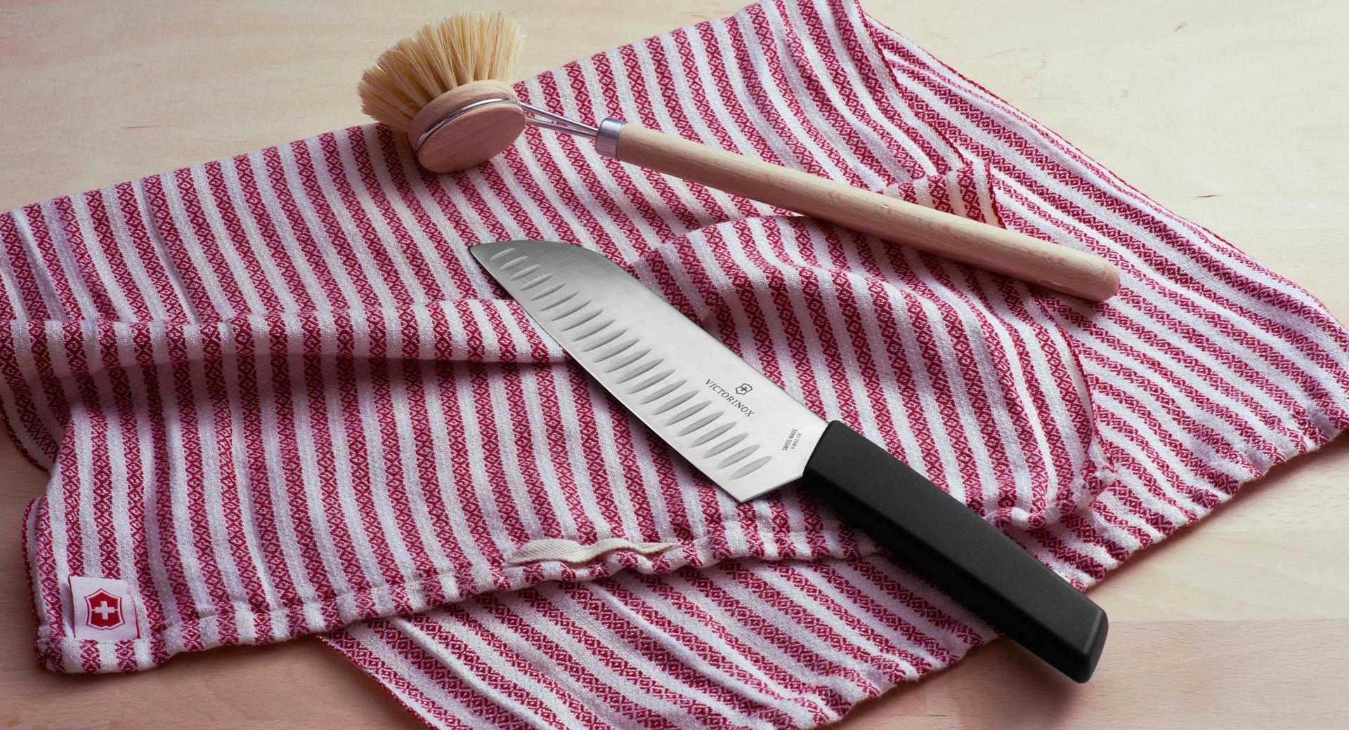 La mano del cuoco con un coltello affetta il pane su un tagliere da cucina